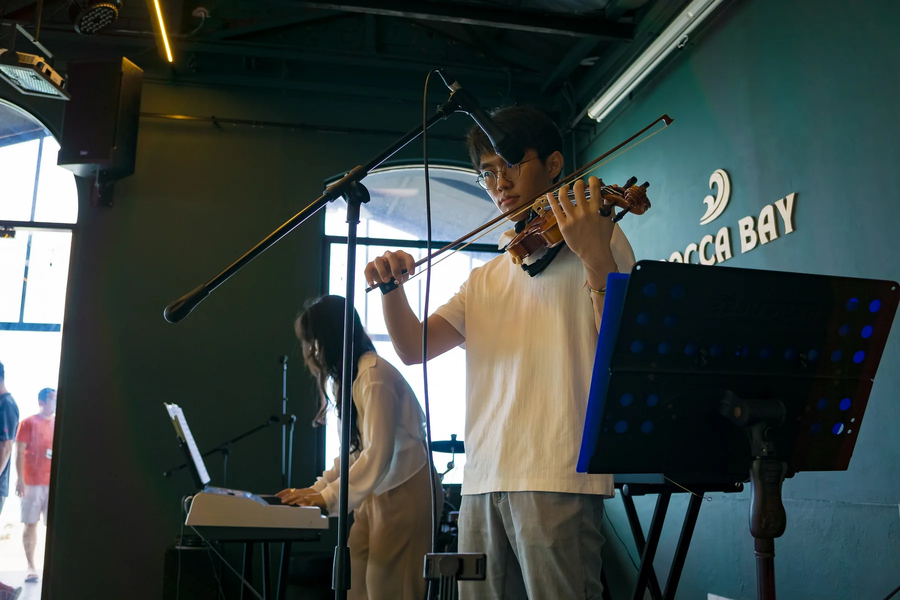 Young violinist performing with a keyboard accompanist at an Expressivo event